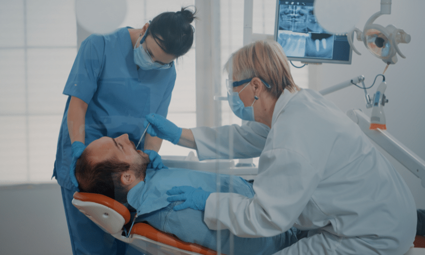 Periodontal Treatment Phoenix (2) Dentist and dental assistant examining patient for periodontitis treatment in Phoenix office.