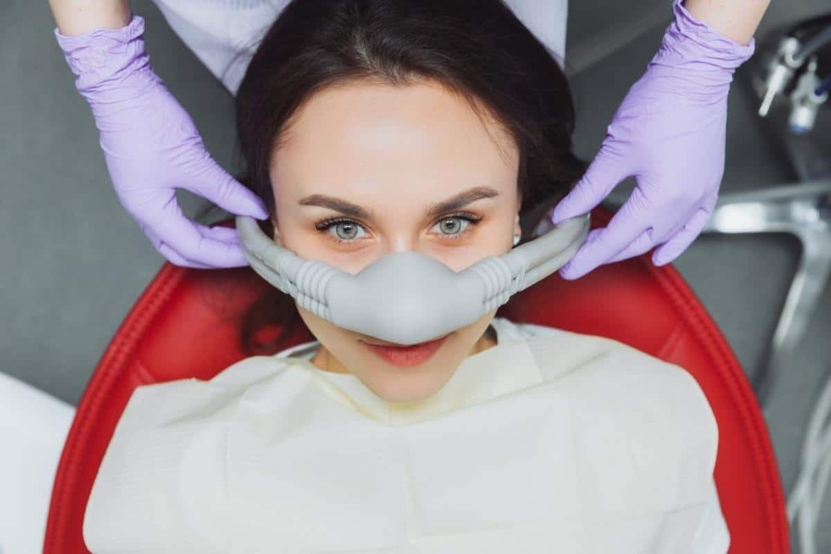 Patient receiving sedation dentistry treatment with nitrous oxide mask at Phoenix dental practice.
