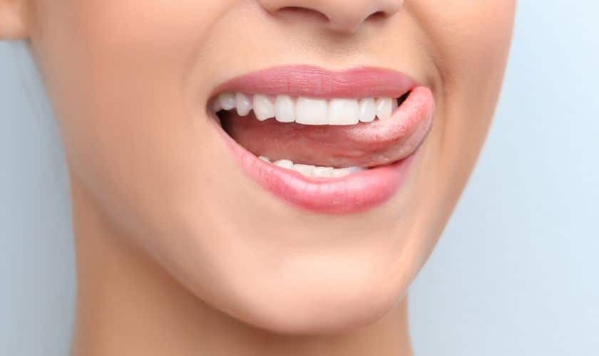 Close-up of a patient's healthy smile showing white teeth and pink lips after crown lengthening treatment.