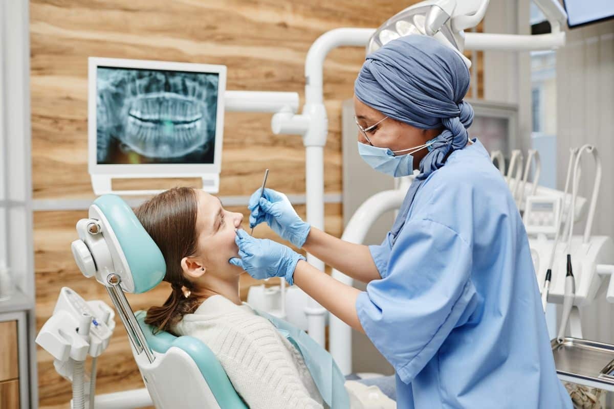 dental bone grafting (2) Dentist examining patient's teeth during dental procedure in Phoenix office.