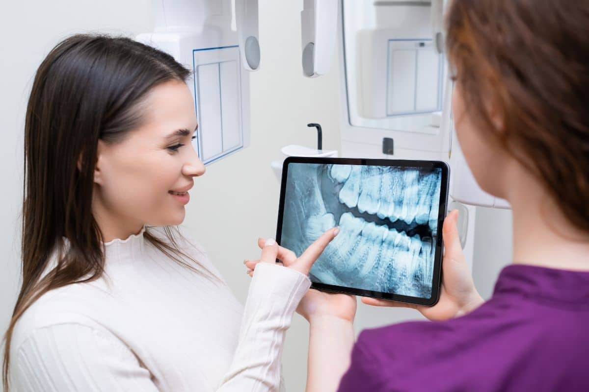 Dental Bite Adjustment Dentist showing patient dental X-ray on tablet in Phoenix office.