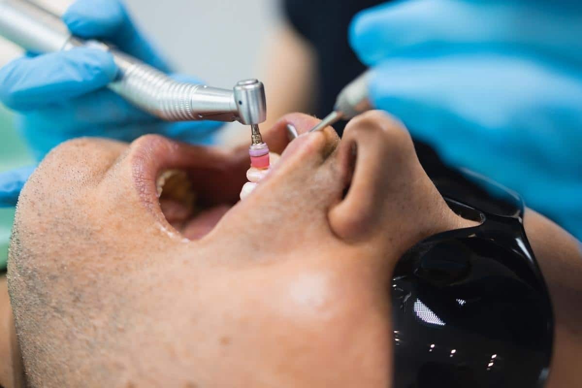 Why Phoenix Patients Are Switching To Laser Gum Therapy Dentist performing laser gum therapy treatment on patient in Phoenix dental office.