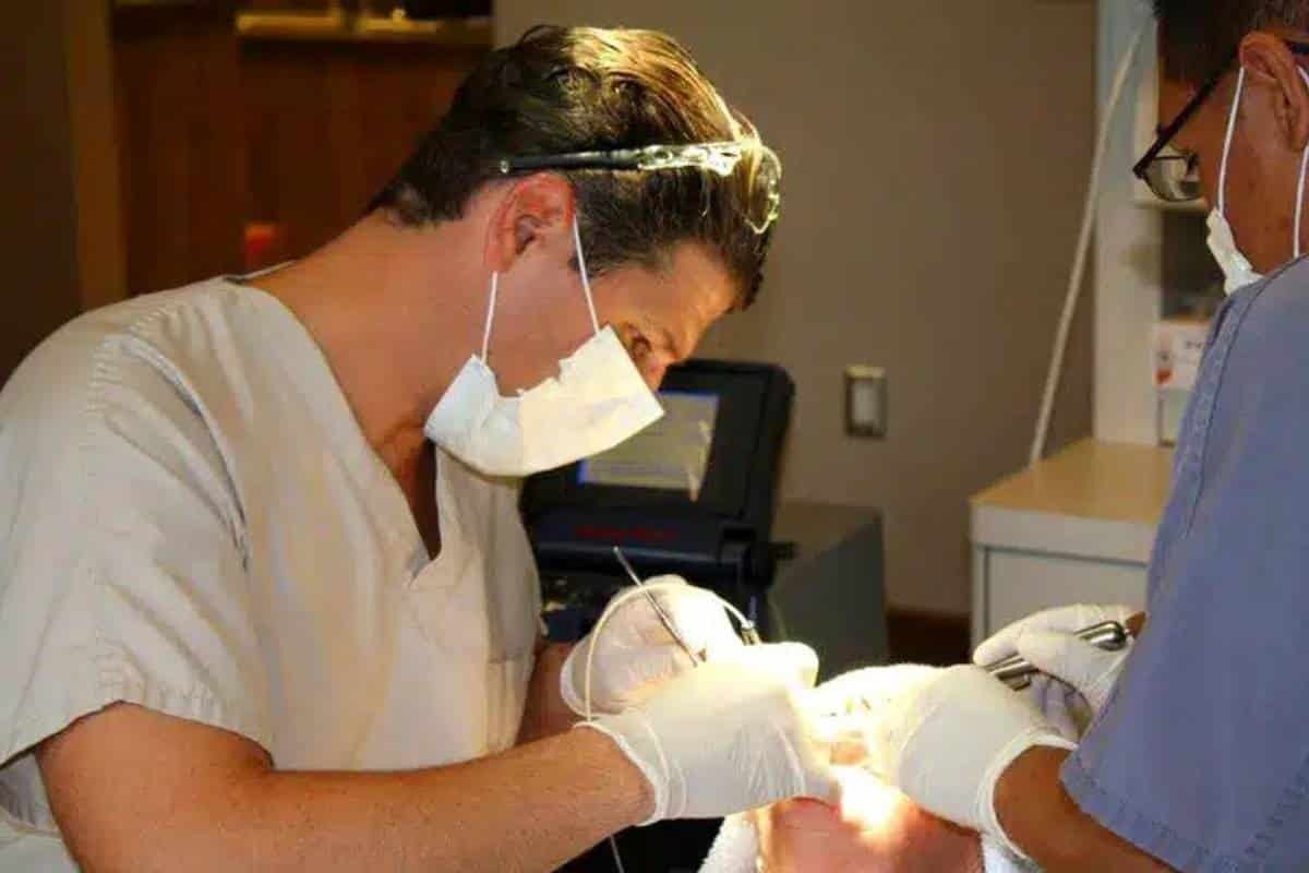 Dentist performing gum graft surgery on patient in Phoenix dental office.